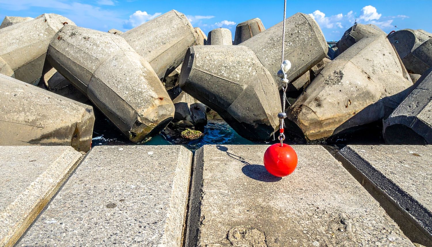 テトラポッドの隙間から根魚を狙う穴釣りの様子